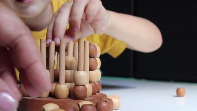 logic wooden board game and a boy playing with it close-up