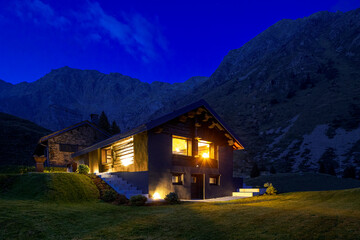 Modern mountain chalet in the middle of the evening as the sun sets and the night rises. Beautiful...