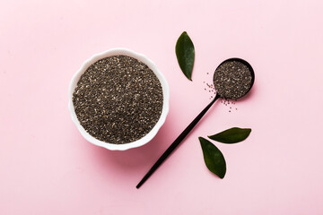 Chia seeds in bowl and spoon on colored background. Healthy Salvia hispanica in small bowl. Healthy...