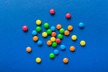 Mixed collection of colorful candy, on colored background. Flat lay, top view. frame of colorful chocolate coated candy