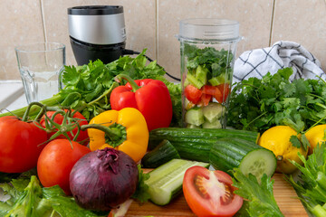 Making vegetable smoothie with fresh vegetables in a blender. Health food and living concept.