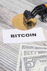 Bitcoin, miniature excavator and dollars. Cryptocurrency. International network payment. Finance concept