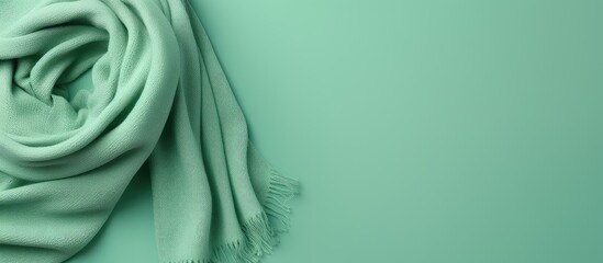 Gorgeous green wool scarf on isolated pastel background Copy space - obrazy, fototapety, plakaty