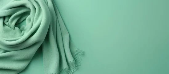 Poster Gorgeous green wool scarf on isolated pastel background Copy space © Ilgun