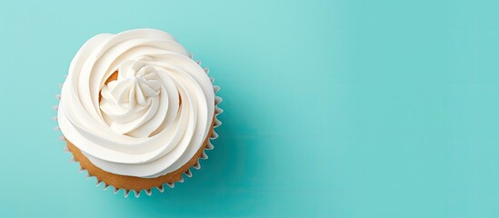 Teal cupcake with butter cream frosting alone on a isolated pastel background Copy space - obrazy, fototapety, plakaty