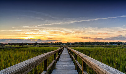 wooden dock on the inlet at Pawleys Island in South Carolina in warm golden light at sunset