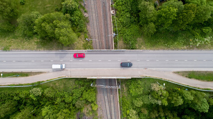 Three Cars On A Bridge Crossing Railroad