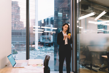 Concentrated businesswoman chatting on mobile phone during workday in office