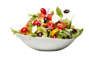 Fresh Greek salad ingredients dropped into bowl on a white background studio shot