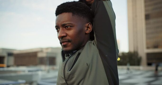 Fitness, health and stretching with a black man runner outdoor in a city for marathon or cardio training. Exercise, workout and a young athlete getting ready for the start of his workout for wellness