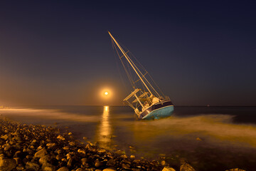 velero encallado en una playa de Marbella a la luz de la luna