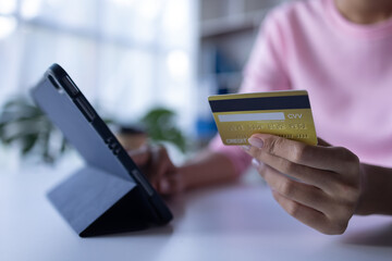Women holding credit card and using smartphones at home.Online shopping, internet banking, store online, payment, spending money, e-commerce payment at the store, credit card, concept
