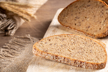 Slices of fresh rye bread with grains lie on the kitchen board,