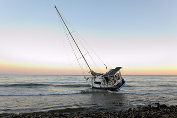 velero encallado en una playa de Marbella al atardecer
