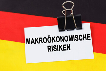 On the flag of Germany lies a business card with the inscription - macroeconomic risks