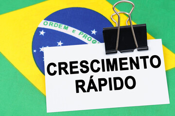 On the flag of Brazil lies a business card with the inscription - rapid growth