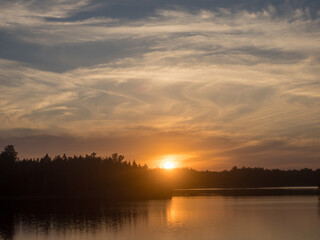 Fototapeta na wymiar cloudy sunset on a forest lake