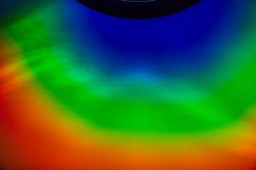 Partial black circle at top with abstract waves of blue and green and red in arc background asset