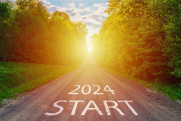 New year 2024 concept. Text 2024 written on the road in the middle of asphalt road with at sunset. Concept of planning, goal, challenge, new year resolution.Toned. - obrazy, fototapety, plakaty