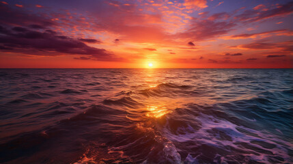 Fototapeta na wymiar The horizon burns with a fiery orange and deep magenta, as the sun dips below the ocean.