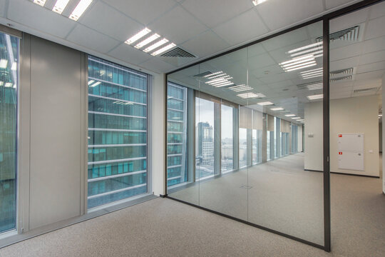 Spacious office space with light walls, panoramic windows and a glass partition.