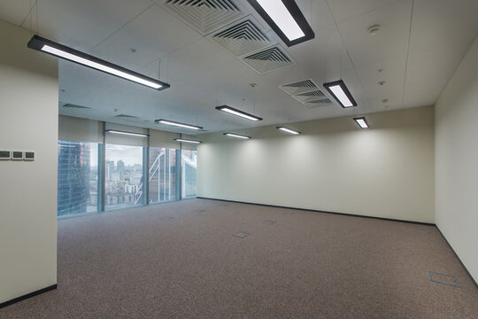 An empty office open space with light walls, panoramic windows, unfurnished.