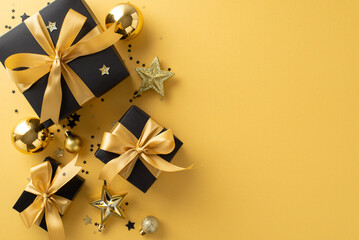 Unwrap magic of season with New Year luxury gift idea. Top view of black gift boxes, golden bows, festive tree ornaments, stars, confetti on yellow background. Perfect for holiday messages or promo