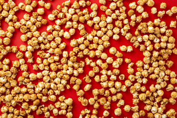 A captivating movie night scene with a heap of tasty popcorn on a vibrant red backdrop, leaving room for text or ads