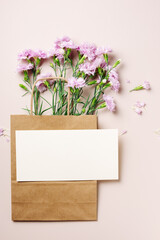 Pink carnation flowers in a paper bag, card mockup.