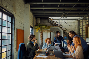 Young and diverse group of designers having a meeting in an office while working in a startup company