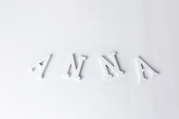 inscription on a white background ANNA. white wooden letters. empty space for text