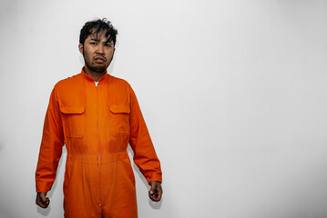 Prisoner in orange robe concept,Portrait of asian handsome man in Prison uniforms,Bandit has a lot...