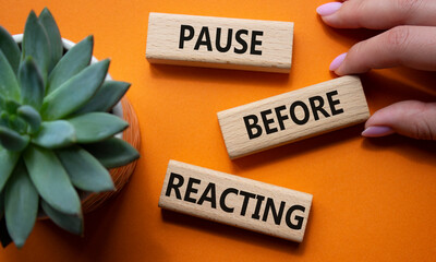 Pause before Reacting symbol. Concept words Pause before Reacting on wooden blocks. Beautiful...