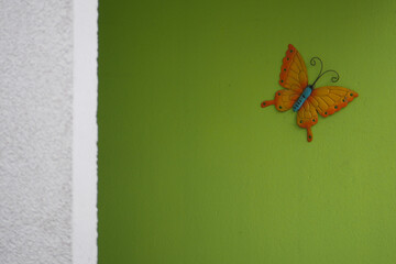 Fototapeta na wymiar butterfly painted on a green wall of an apartment building