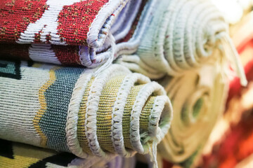 Pile of beautiful handmade carpets on the traditional Middle East market bazaar. Woven cotton...