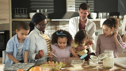 Young interracial blended family baking and being messy in the kitchen at home - Powered by Adobe