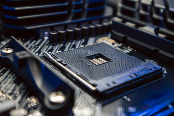 AM4 CPU Socket on motherboard of powerful PC. Computer hardware chipset components close-up in blue...