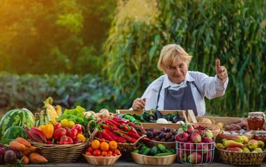 old woman farmer sells vegetables and fruits at the farmers market. Selective focus.