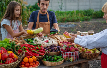 Father and daughter sell vegetables and fruits at the farmers market. Selective focus.