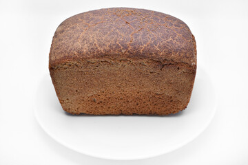 A black loaf of bread on a white background. Freshly baked bread.