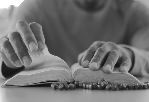 man praying with bible with black background with people stock image stock photo
