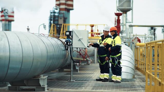 Man engineer supervisor examining energy control installation panel at manufacture oil gas plant