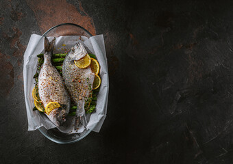 raw baked dorado fish with asparagus and lemon in spices