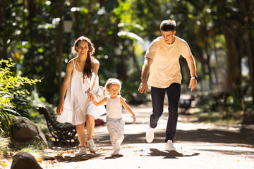 Young family running in the summer park