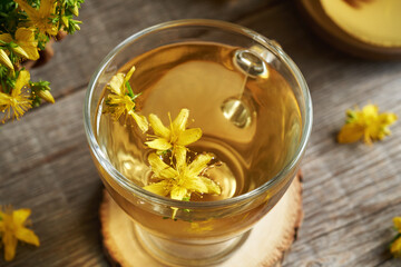 Closeup of St. John's wort blossoms in a cup of herbal tea
