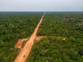 Drone shot of the famous BR-319 in dry season, a dirt road through the Amazon rainforest between...