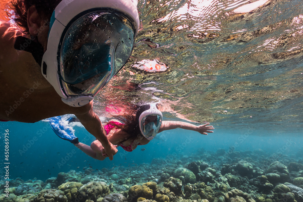 Wall mural young attractive couple with snorkeling gear, couple enjoy snorkeling in the ocean, coral watching a