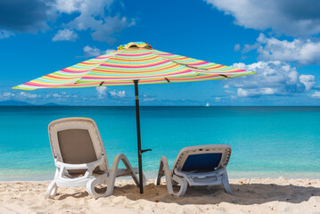Beach umbrella in foreground with a turquoise cystal water of caribbean sea in background