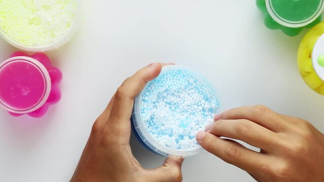 ASMR video. The slime is blue with white foam balls. Sticky relaxation video, 