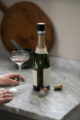 Champagne bottle and woman’s hand with glass
